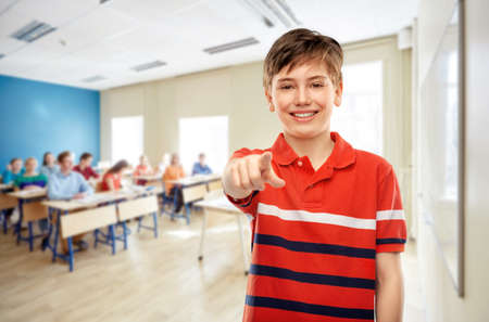 student boy pointing finger to camera at schoolの写真素材