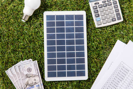solar battery, bulb, money, bills and calculatorの写真素材