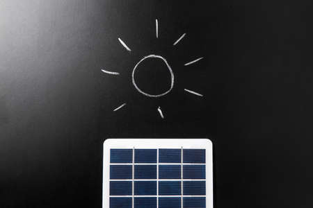 close up of solar battery and sun on chalkboardの写真素材