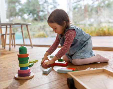happy baby girl playing with toy blocks at homeの写真素材