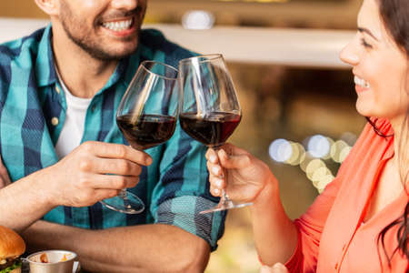 close up of couple drinking red wine at restaurant