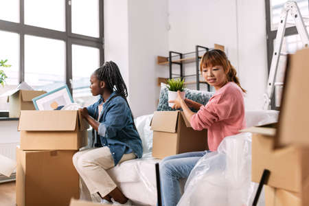 women unpacking boxes and moving to new home