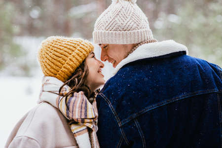 couple looking at each other in winter forestの写真素材