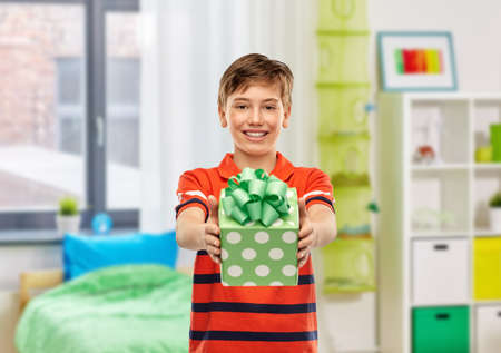 portrait of smiling boy with birthday gift at homeの写真素材