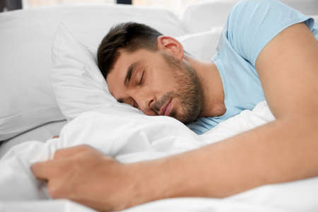 man sleeping in bed at home