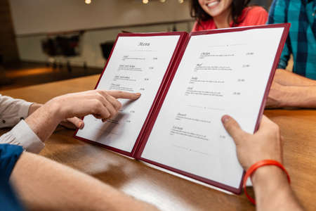 close up of couple with menu at restaurantの写真素材