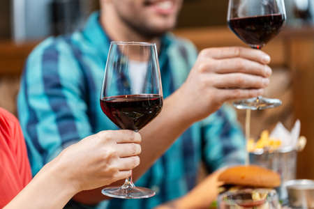 happy friends drinking red wine at restaurant