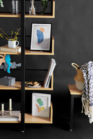 book shelf with art and home decor over black wall