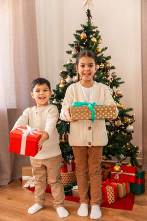 happy children with christmas gifts at home