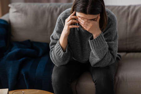 stressed woman with medicine calling on phone