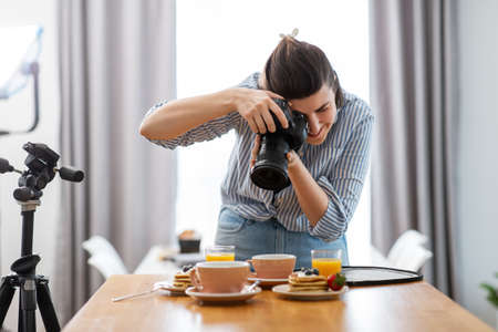food photographer with camera working in kitchenの写真素材