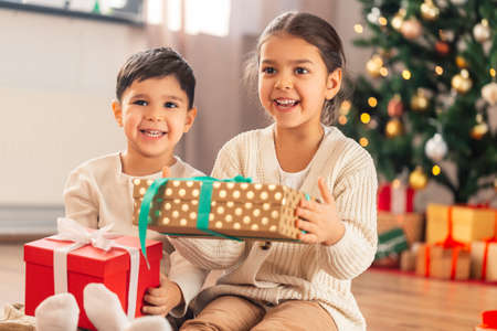 happy children with christmas gifts at homeの写真素材