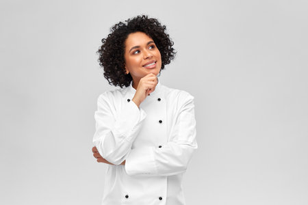 smiling female chef in white jacketの写真素材