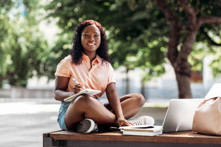 african student girl with laptop and books in cityの写真素材