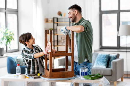father and son cleaning old table with tissueの写真素材