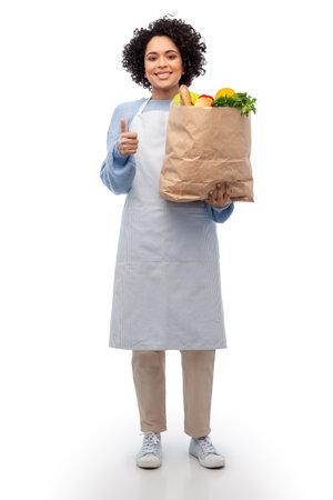 woman in apron with takeaway food in paper bagの写真素材