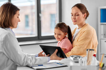 mother, child and doctor with tablet pc at clinicの写真素材