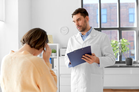 doctor and woman with health problem at hospitalの写真素材