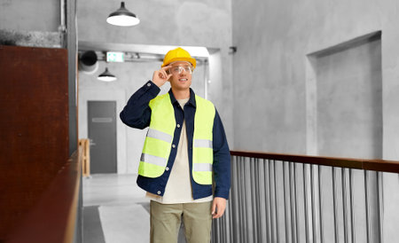 male builder in helmet and goggles at officeの写真素材