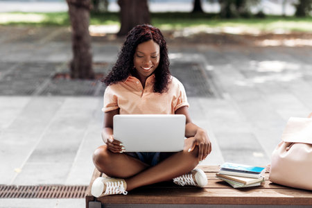 african student girl with laptop and books in cityの写真素材