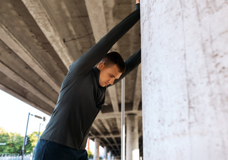 man stretching back under bridgeの写真素材