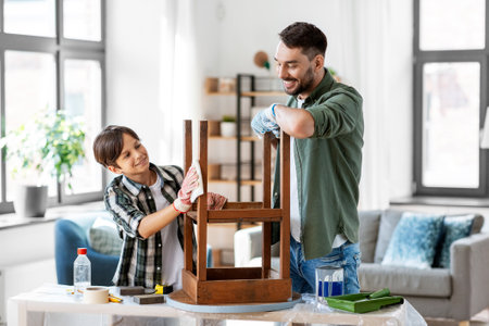 father and son cleaning old table with tissueの写真素材