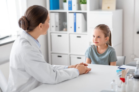 female doctor and little girl patient at clinicの写真素材