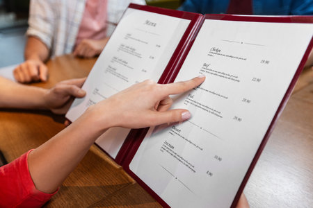 close up of couple with menu at restaurantの写真素材