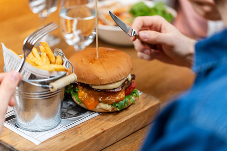 close up of man eating burger and french friesの写真素材