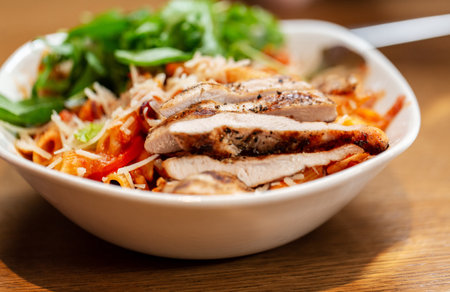 close up of chicken pasta with vegetables on plateの写真素材