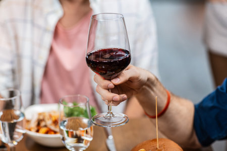 man with glass drinking red wine at restaurantの写真素材