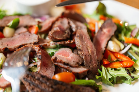 close up of meat with vegetable salad on plateの写真素材