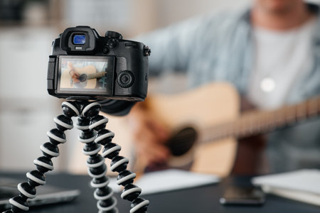 camera recording video of man playing guitarの写真素材