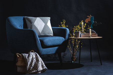 blue chair and blanket in basket over black wall