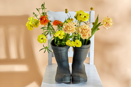flowers in rubber boots on vintage chairの写真素材