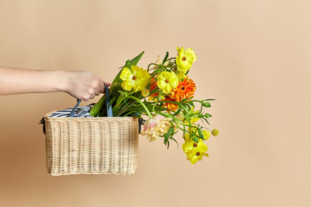 close up of hand holding basket with flowersの写真素材