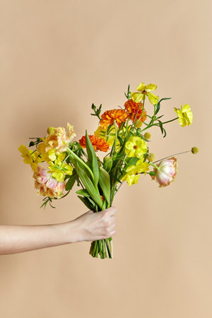 close up of hand holding bunch of flowers