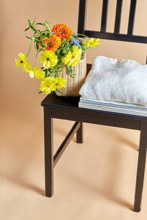 flowers in basket, clothes and hat on old chairの写真素材