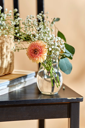 flowers in vase on chair over beige backgroundの写真素材