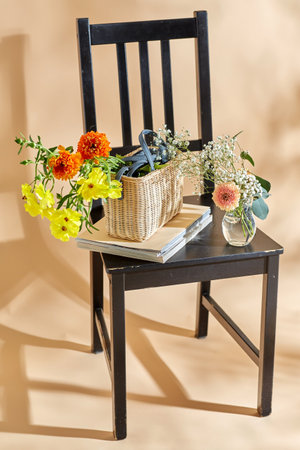flowers in basket on chair over beige backgroundの写真素材