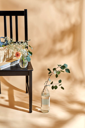 flowers in basket on chair over beige backgroundの写真素材