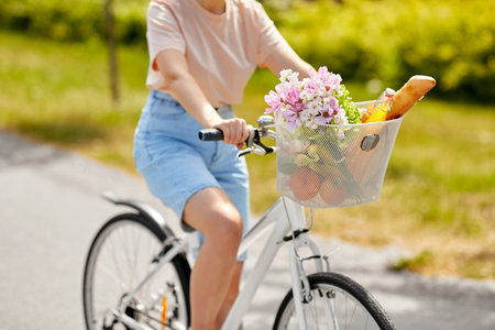 woman with food and flowers in bicycle basketの写真素材