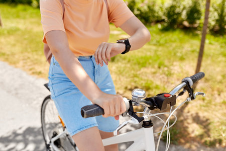 woman with smart watch riding bicycle in cityの写真素材