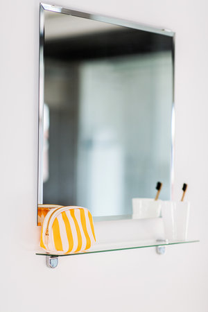 cosmetic bag and toothbrush on mirror in bathroomの写真素材