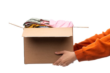 hands holding cardboard box with clothesの写真素材