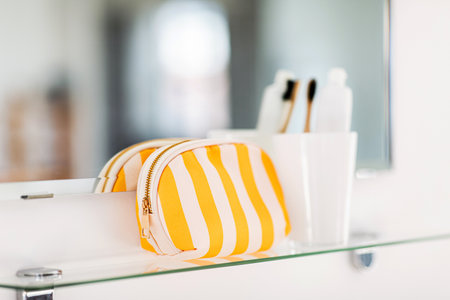 cosmetic bag and toothbrush on mirror in bathroomの写真素材