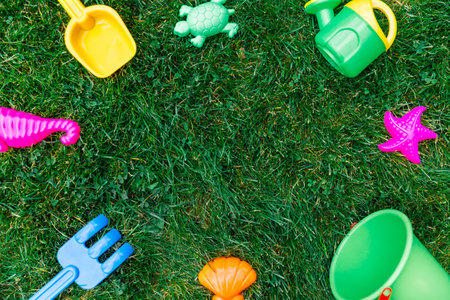 close up of sand toys kit on green lawn or grassの写真素材