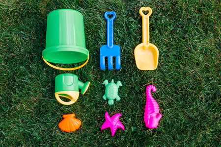 close up of sand toys kit on green lawn or grassの写真素材