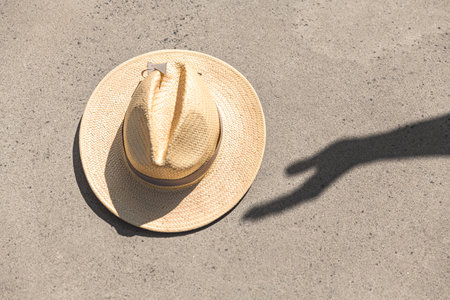shadow of hand touching real straw hatの写真素材