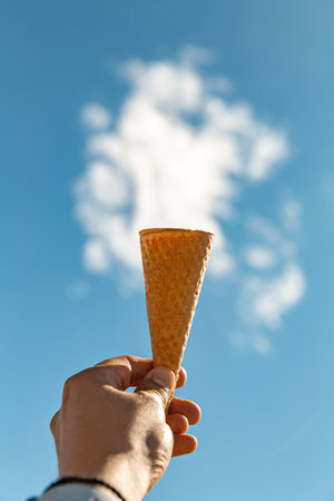 close up of hand holding waffle ice cream coneの写真素材